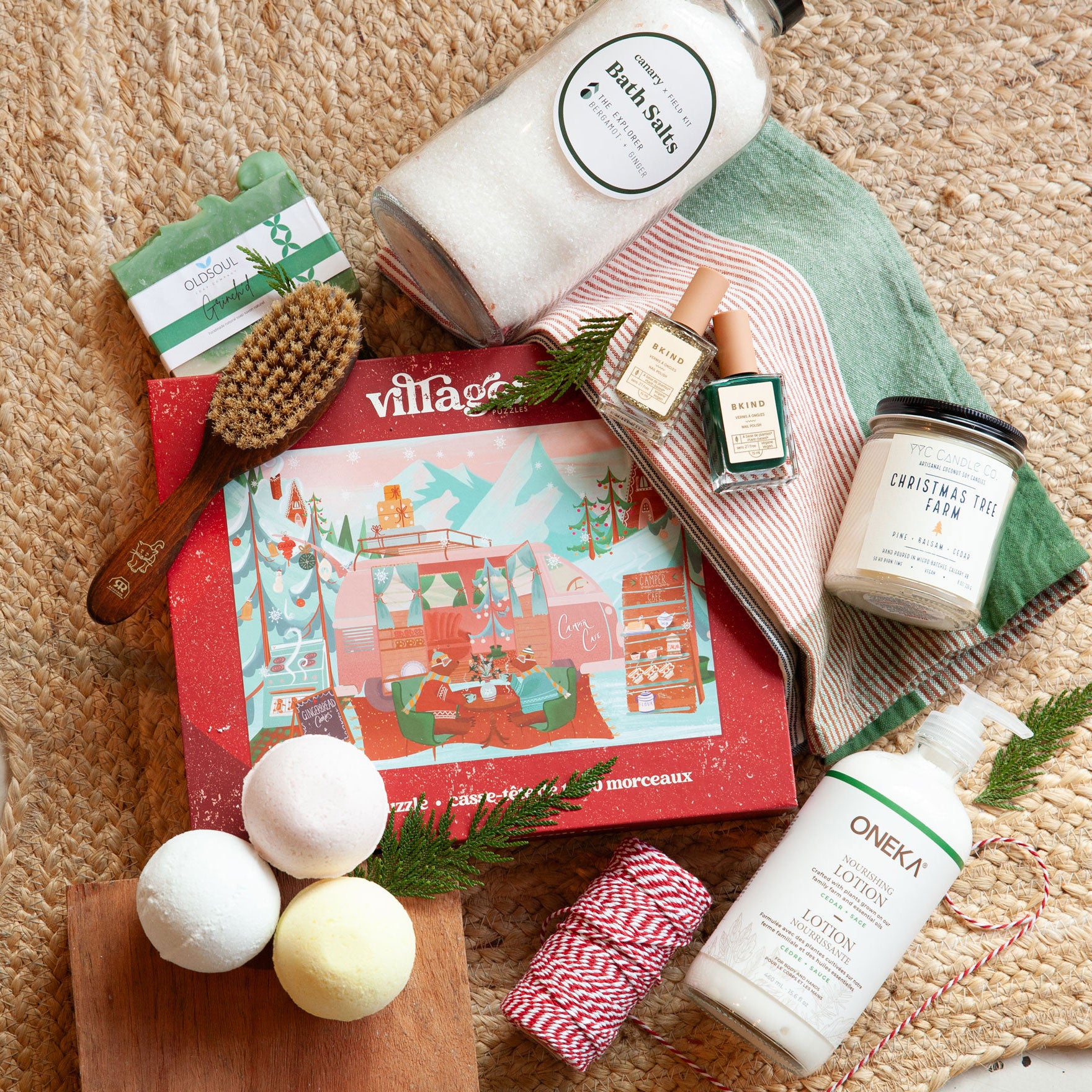 Collection of self-care products including bath salts, candles, and lotion on a textured surface with a decorative box.